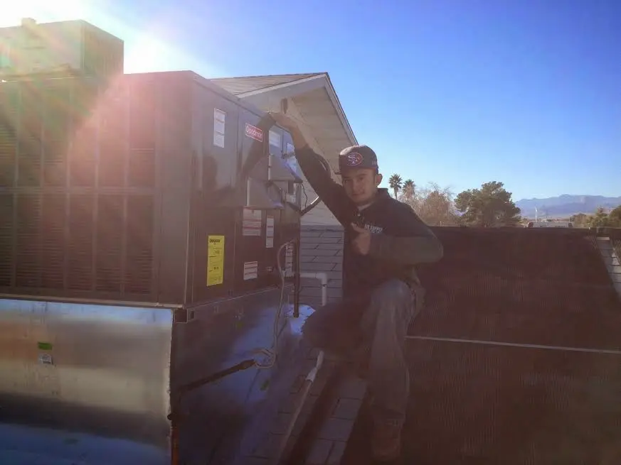 HVAC technician performing AC Tune-Up on a rooftop unit in Woodlawn